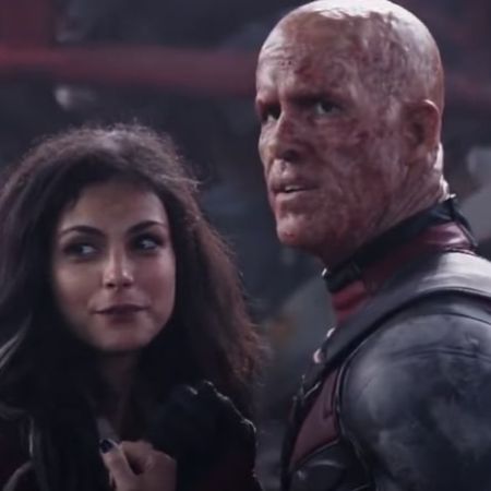 Morena Baccarin is standing next to Deadpool in the picture.